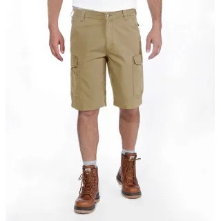 Mężczyzna nosi beżowe spodenki cargo Carhartt Rigby Rugged, które sięgają do kolan. Ma na sobie brązowe skórzane buty i białą koszulkę, a tło jest jednolite i białe.