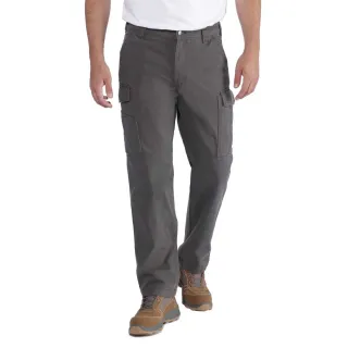 Mężczyzna ubrany w szare spodnie cargo Carhartt Rigby i brązowe buty stoi na białym tle. Spodnie mają kieszenie boczne i są zestawione z białą koszulką.